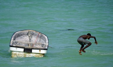 Paje, Zanzibar - Ekim 2024: Yerli çocuklar tekneden atlarken eğleniyorlar