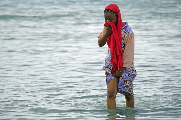 Nungwi, Zanzibar - Ekim 2024: Sular çekildiğinde okyanustan deniz ürünleri toplayan kadın