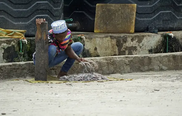 nungwi, zanzibar - Ekim 2024: Genç yetişkin adam yerel balıkçıda taze ahtapot hazırlıyor