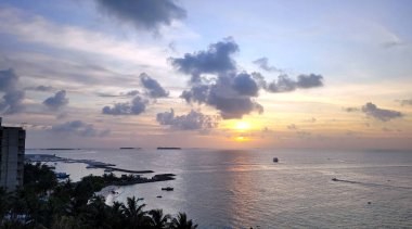 Maldivler 'de güneşli tropik bir sahil cenneti manzarası.