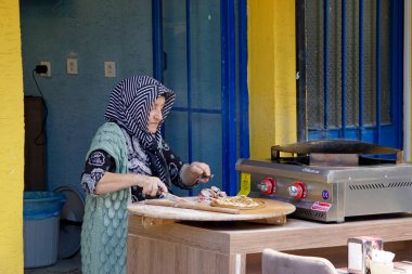 İstanbul, Türkiye - 22 Mayıs 2025: Ekmek hazırlayan yaşlı kadın