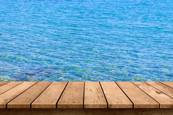 Mavi deniz arka planlı ahşap masa..