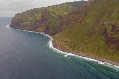 Kıyı şeridi ve terk edilmiş küçük köyün bulutlu yaz gününde insansız hava aracı görüntüsü