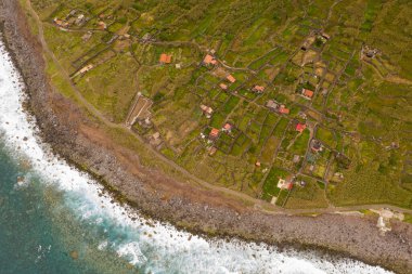 Kıyı şeridi ve terk edilmiş küçük köyün bulutlu yaz gününde insansız hava aracı görüntüsü