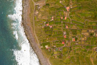 Kıyı şeridi ve terk edilmiş küçük köyün bulutlu yaz gününde insansız hava aracı görüntüsü