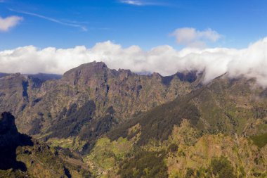 Yaz günü bulutların altında gömülü dağların drone görüntüsü