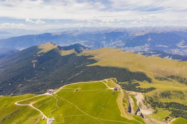 Drone photography of dolomite mountain range and mountain meadow during summer time
