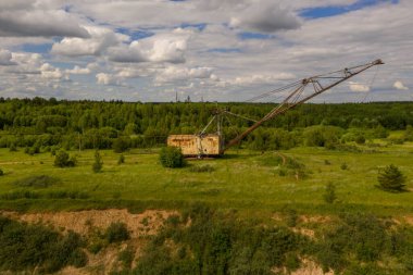 Drone photography of old abandoned excavator in quarry during summer day
