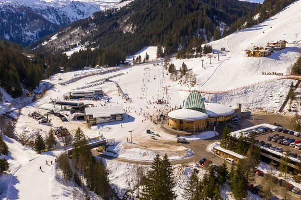 Güneşli kış günlerinde kayak merkezinin, otoparkın, dağların ve ormanın insansız hava aracı fotoğrafları.