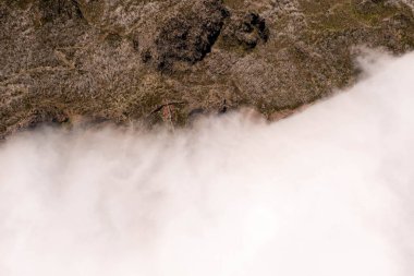 Dağ zirvelerinin drone fotoğrafçılığı ve yaz güneşli bir günde dağ sıra bulutları durdurma. Tam üstte