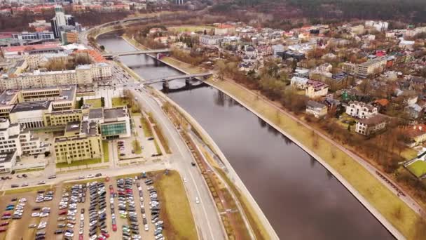 市内を流れる川のドローン映像や 曇り空の春の日の橋 角度の高いビュー 都市景観 — ストック動画