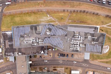 Bulutlu bahar gününde ofis çatılarının ve güneş panellerinin drone fotoğrafları. Tam üstte