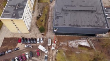 Bulutlu bir bahar sabahı bir binaya işaret asan insanların insansız hava aracı görüntüleri. Yüksek açı görünümü
