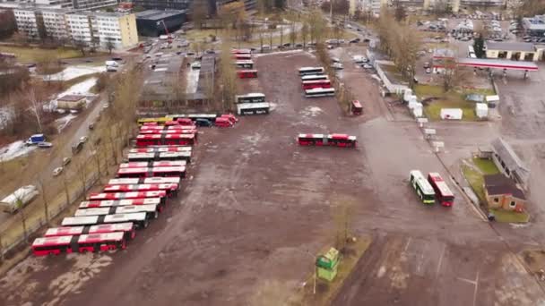 春の朝の都市バス公園 駐車バスや街並みのドローン映像 高角度表示 — ストック動画