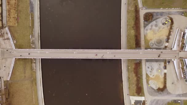 早春の曇りの日には 歩行者用歩道橋や川を歩く人々のドローン映像 — ストック動画