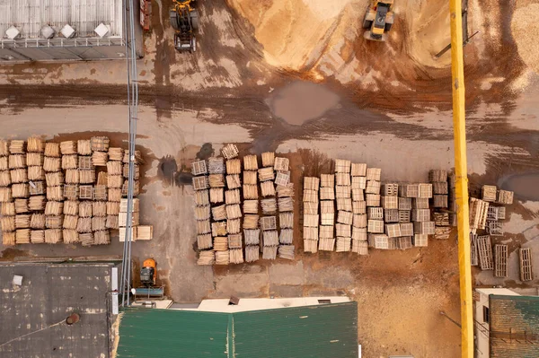Drone footage of sawmill, machinery and lumber during summer day. Directly above