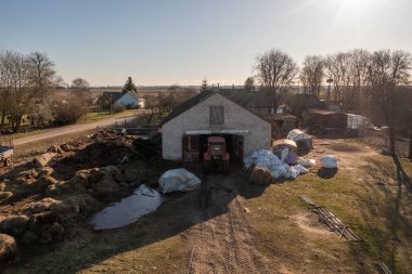Traktör fotoğrafçılığı bahar sabahı çiftlik hayvanlarıyla saman balyalarını kulübeye götürüyor..