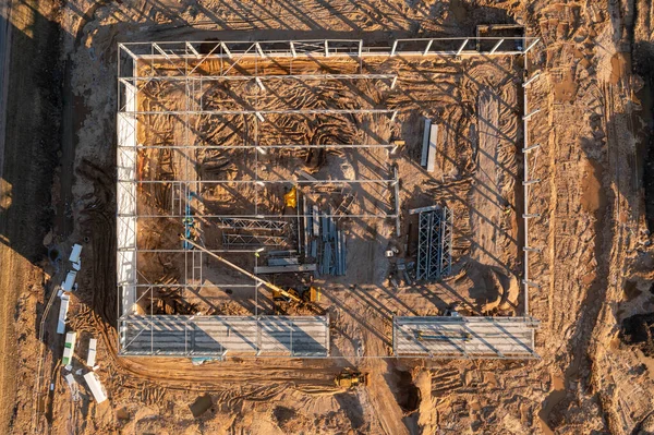 Drone photography of warehouse being built by construction workers during spring morning