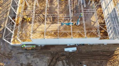 İnşaat işçilerinin bahar sabahı bir depo inşa ettiklerinin drone görüntüleri.