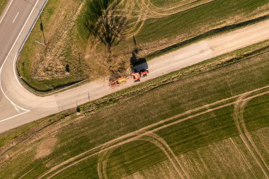 İlkbahar günü, traktörün tarımsal ekipmanlarla çekilen insansız hava aracı görüntüleri..