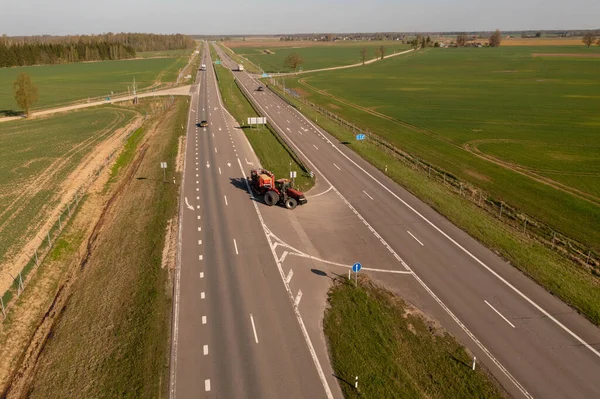 Drone Fotografia Ciągnika Sprzętem Rolniczym Jazdy Drodze Podczas Wiosennego Dnia — Zdjęcie stockowe