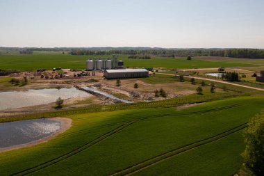 Baharın güneşli günlerinde tarım arazilerinin ve çiftlik binalarının insansız hava aracı fotoğrafları.