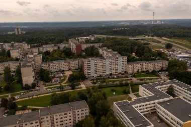 Ağaçlı eski çok katlı apartman kompleksinin insansız hava aracı fotoğrafları ve yaz bulutlu bir günde bolca yeşillik..