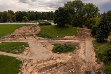 Yaz bulutlu bir günde şehrin ortasında parkın yeniden inşa edilişinin insansız hava aracı fotoğrafları.
