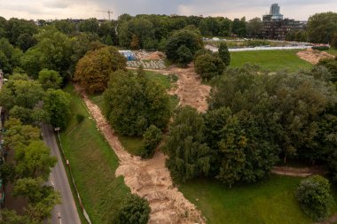 Yaz bulutlu bir günde şehrin ortasında parkın yeniden inşa edilişinin insansız hava aracı fotoğrafları.