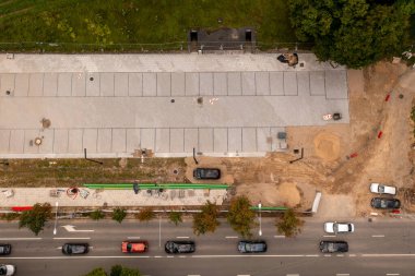 Otopark inşaatlarının insansız hava aracı fotoğrafları bulutlu yaz günlerinde bir parkın yakınındaki bir şehri gösteriyor.