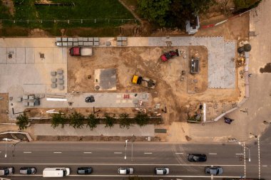 Otopark inşaatlarının insansız hava aracı fotoğrafları bulutlu yaz günlerinde bir parkın yakınındaki bir şehri gösteriyor.