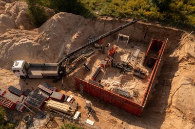 Küçük inşaat alanının insansız hava aracı fotoğrafları ve yaz güneşli bir günde bina inşa eden işçiler.