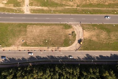 Yaz günü bir kentte bir otoyolun ve inşaatın insansız hava aracı fotoğrafları çekiliyor.