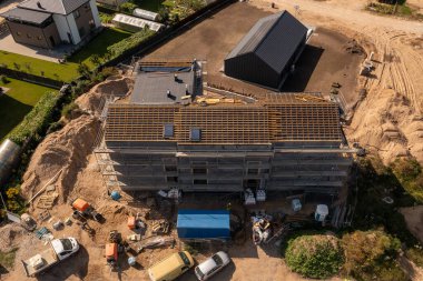 Güneşli bir sonbahar gününde yeni konut inşaatı iskelesi ve çatı iskelesinin insansız hava aracı fotoğrafları.