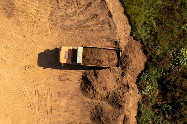 Güneşli bir sonbahar gününde büyük kamyonun toprak taşıdığı drone fotoğrafları.