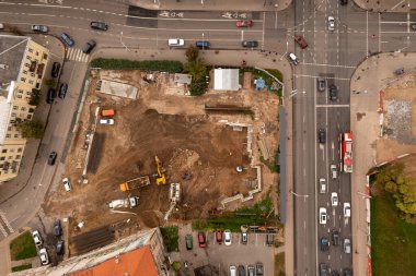Sonbahar günü caddelerle çevrili bir şehrin ortasındaki inşaat sahasının insansız hava aracı fotoğrafları.