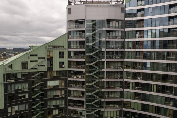 Drone photography of residential building, glass and reflection during cloudy autumn day.