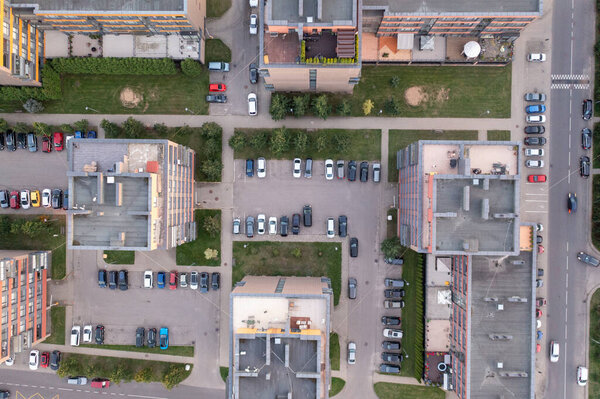 Drone photography of parking place between multistory houses