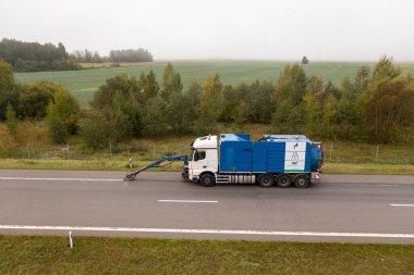 Sonbahar bulutlu bir günde otoyolda yol tabelalarını kaldıran kamyonun robot resmi