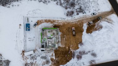 Kışın bulutlu bir günde kırsal bir alanda kişisel bir inşaat alanının insansız hava aracı fotoğrafçılığı