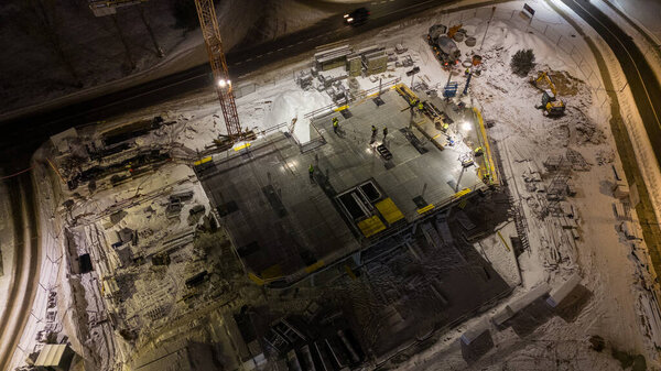 Drone photography of construction site and construction workers working during the winter night