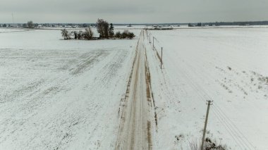 Bulutlu kış gününde küçük kırsal toprak yolun drone fotoğrafçılığı