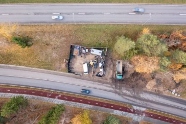 Sonbahar güneşli bir günde sokağın yakınındaki küçük ağır ekipman deposunun insansız hava aracı fotoğrafları.