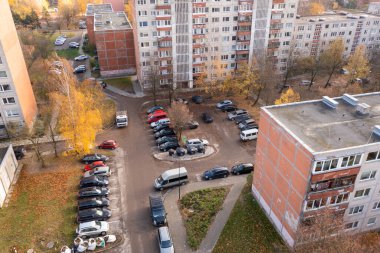 Sonbahar güneşli bir günde şehrin çok katlı evlerinin ve aralarındaki park yerlerinin insansız hava aracı fotoğrafları.
