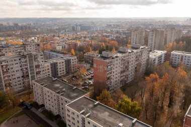 Çok katlı evlerin insansız hava aracı fotoğrafçılığı ve güneşli sonbahar günlerinde şehrin birinde park etmek.