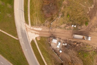 Sonbahar güneşli bir günde inşaat alanına çit kapısından giren bir kamyonun robot fotoğrafı.
