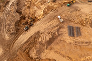 İnşaat alanının ve inşaat makinelerinin sonbahar güneşli günlerinde dağıtım yapan insansız hava aracı fotoğrafları.