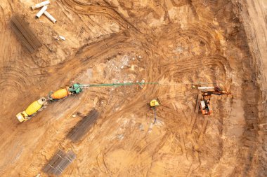 Sonbahar güneşli bir günde inşaat alanına beton taşıyan bir kamyonun insansız hava aracı fotoğrafı.