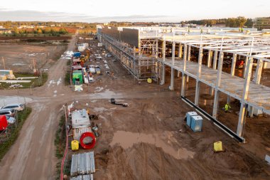 Sonbahar güneşli sabahları inşaat makineleri ve inşaat işçileri olan büyük ticari binaların inşaat alanlarının insansız hava aracı fotoğrafları.