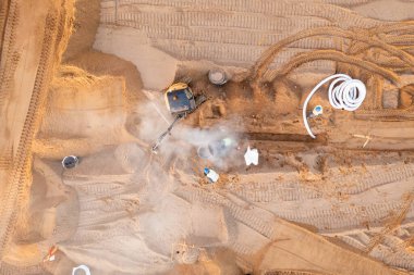 Sonbahar güneşli sabahları inşaat makineleri ve inşaat işçileri olan büyük ticari binaların inşaat alanlarının insansız hava aracı fotoğrafları.